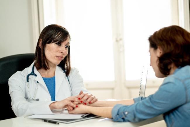 רופאה מבשרת לחולה צעירה על אבחנה של סרטן העור, מלנומה